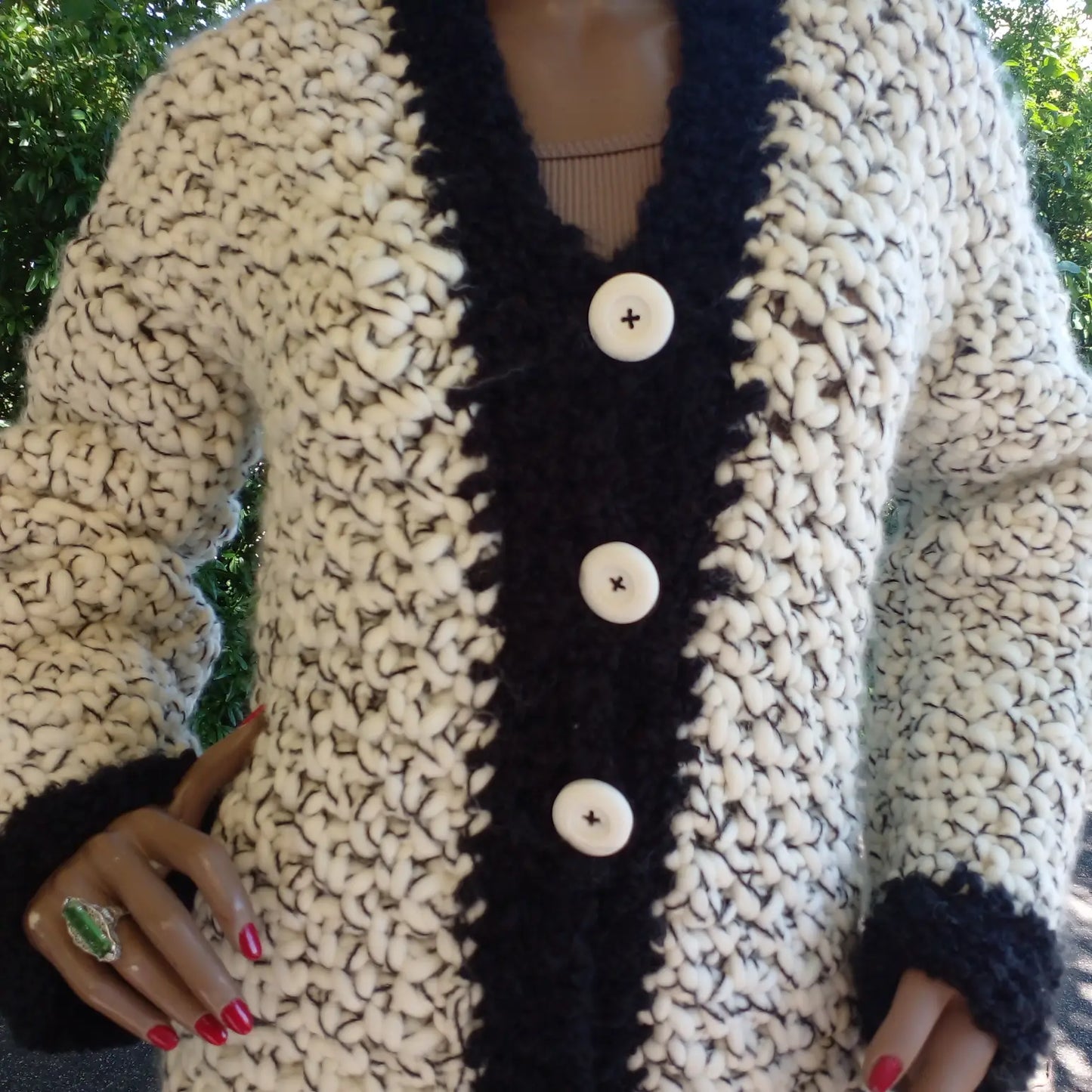 Gilet au crochet Chamoisy de Cachalabibi - Gros plan sur les trois boutons nacrés et les points ajourés