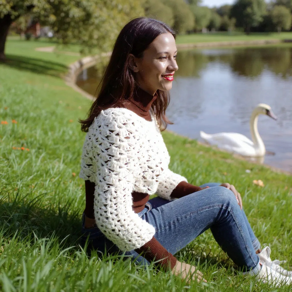Pull court au crochet Corto de Cachalabibi - vue de profil au bord d'un étang avec cygne et verdure
