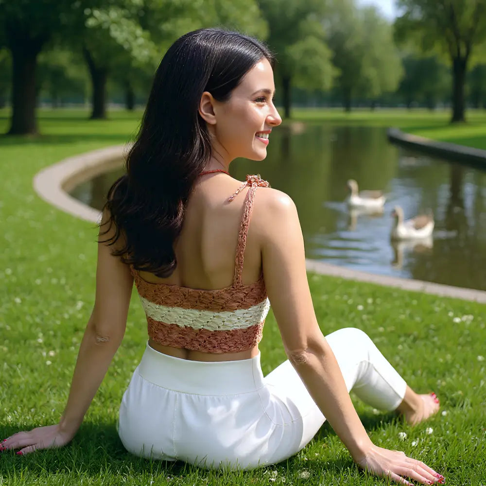 Top au crochet Kiléboceo de Cachalabibi - vue de dos assise dans l'herbe au parc avec des cygnes