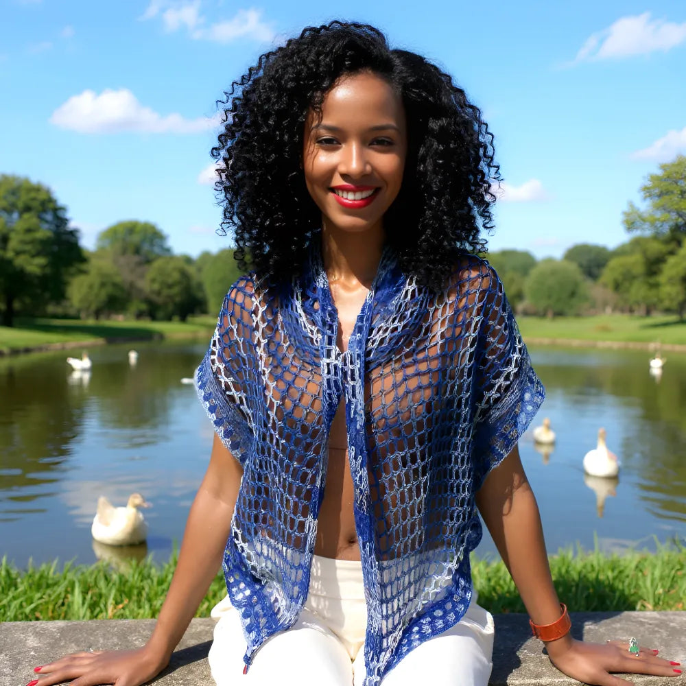 Châle au crochet Amazigh de Cachalabibi - vue de face sur une jeune femme assise sur un bord d'étang