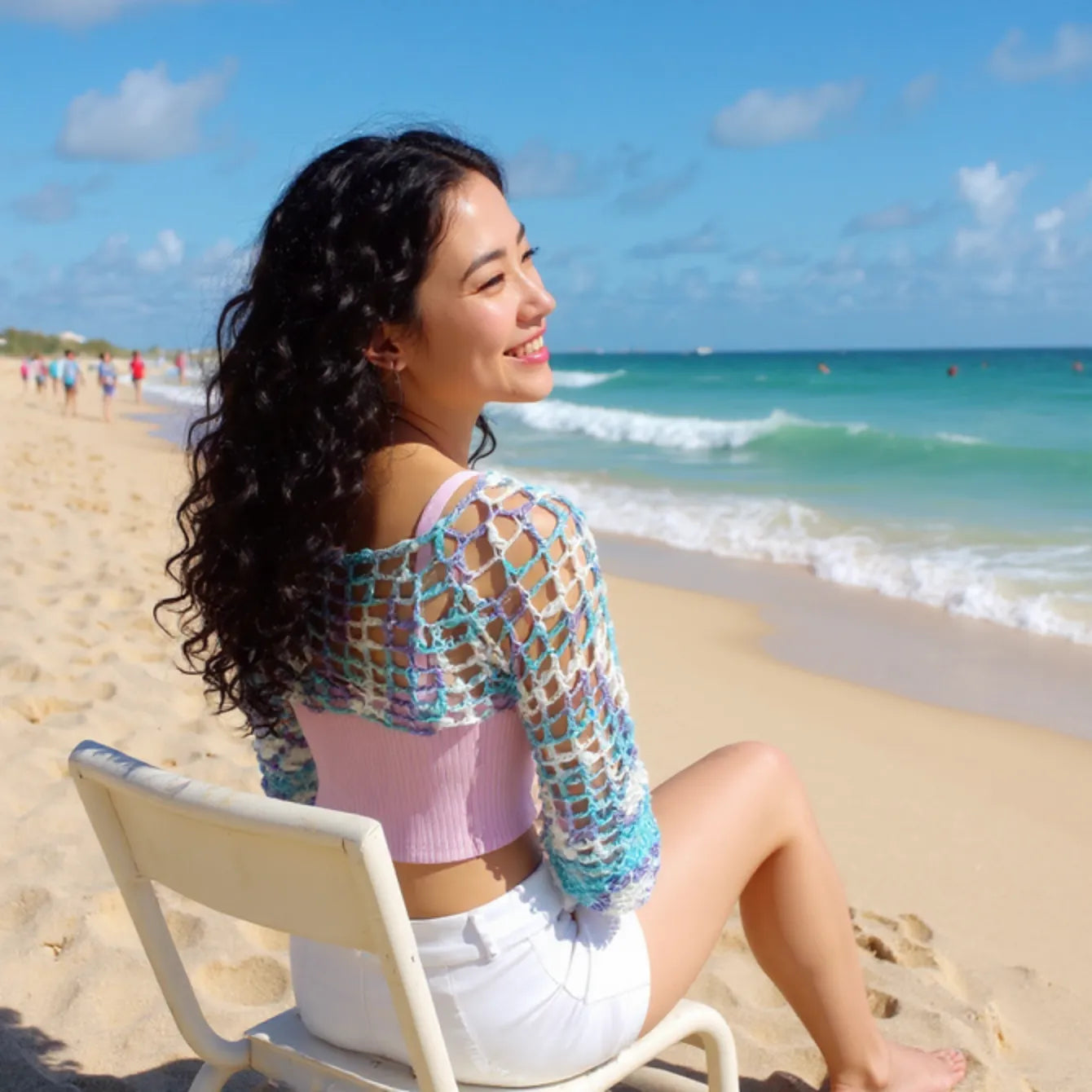Crop top au crochet Ladyblue de Cachalabibi - vue de profil assise sur chaise longue blanche à la plage
