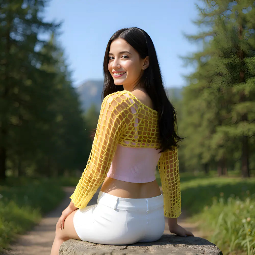 Crop top au crochet Napolitano de Cachalabibi - vue de dos d'une jeune femme assise sur une pierre 