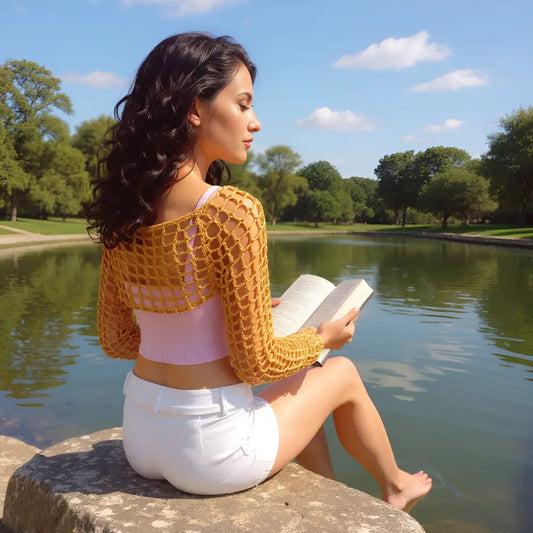 Crop top au crochet Sweetie de Cachalabibi - jeune femme les pieds nus au bord d'un étang avec un livre dans les mains