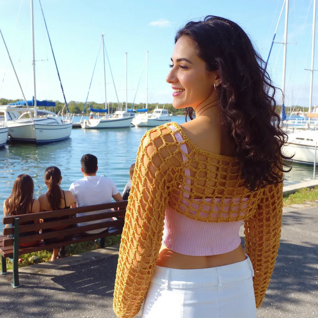 Crop top au crochet Sweetie de Cachalabibi - vue de dos au port de plaisance avec les voiliers et des gens sur un banc