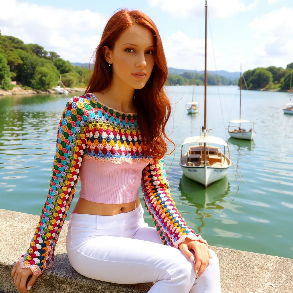 Crop top au crochet Volarino de Cachalabibi - gros plan sur une femme assise sur le parapet d'une marina