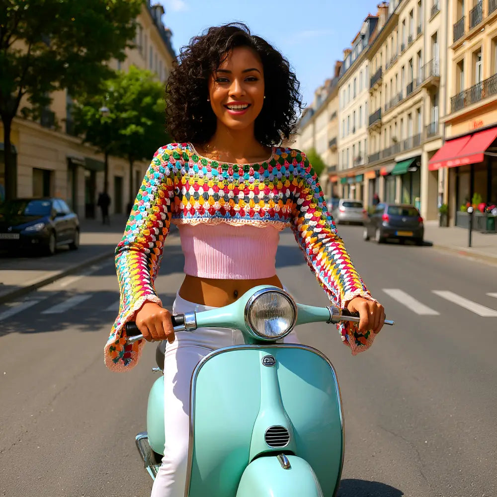 Crop top au crochet Volarino de Cachalabibi - vue de face en scooter Vespa turquoise dans les rues de Paris