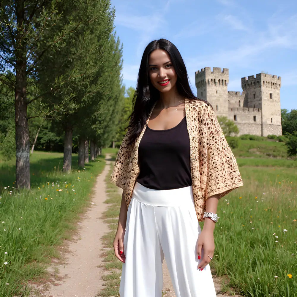 Gilet au crochet Albatros de Cachalabibi - porté par une jeune femme devant un château médiéval