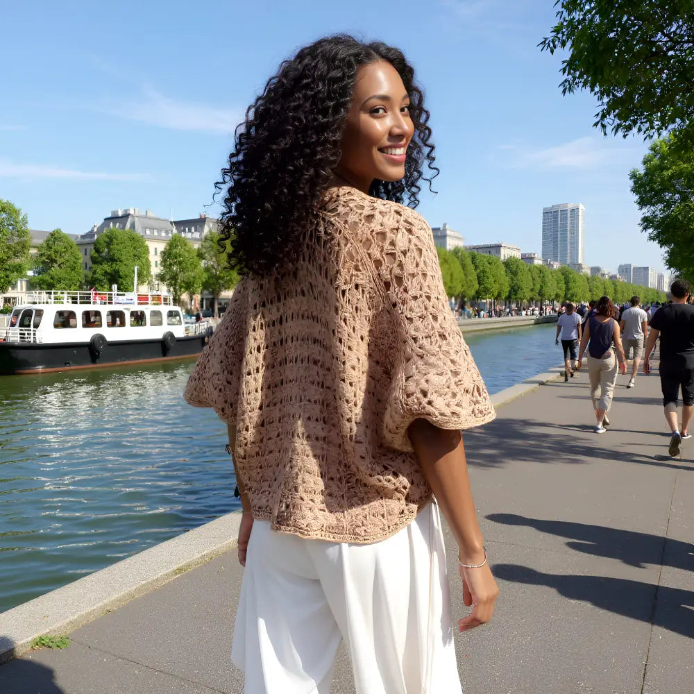 Gilet au crochet Albatros de Cachalabibi  vue de dos sur une jeune femme souriante au bord d'un canal parisien