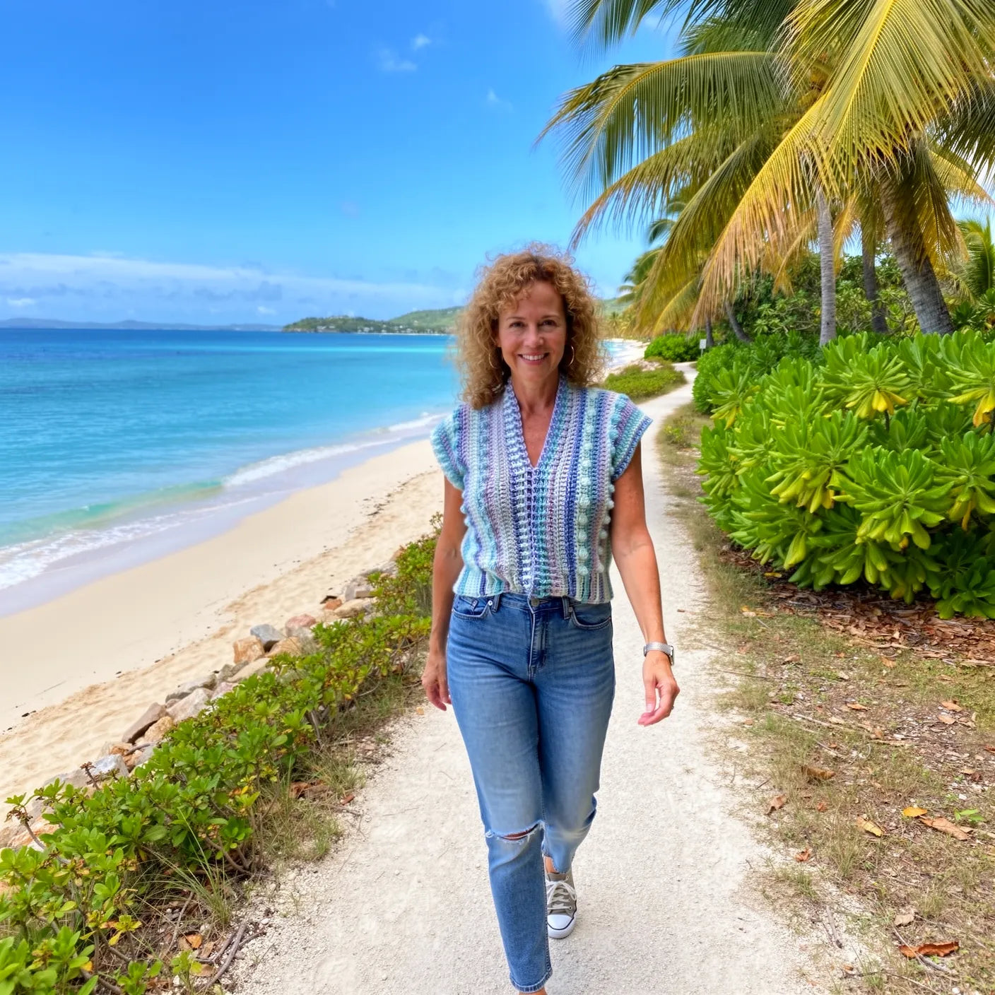 Gilet au crochet Pastello de Cachalabibi -vue de face sur une plage tropicale avec palmiers et océan turquoise
