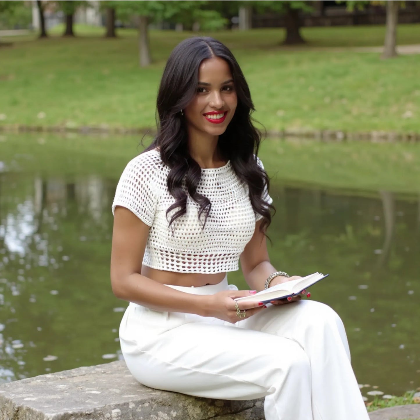 Haut au crochet Bianco de Cachalabibi - vue de face d'une femme avec un livre dans la main près d'un étang