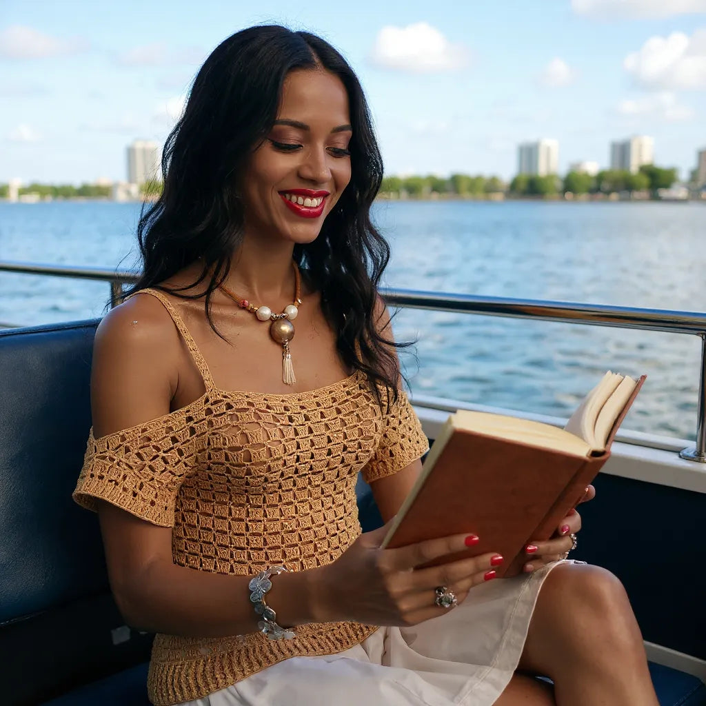 Haut au crochet Caramella de Cachalabibi - jeune femme en lecture sur un bateau avec vue sur la ville