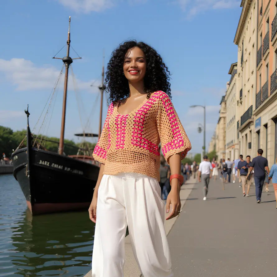 Haut au crochet Cremarosa de Cachalabibi - vue de face d'une femme au bord d'un port de plaisance avec bateaux