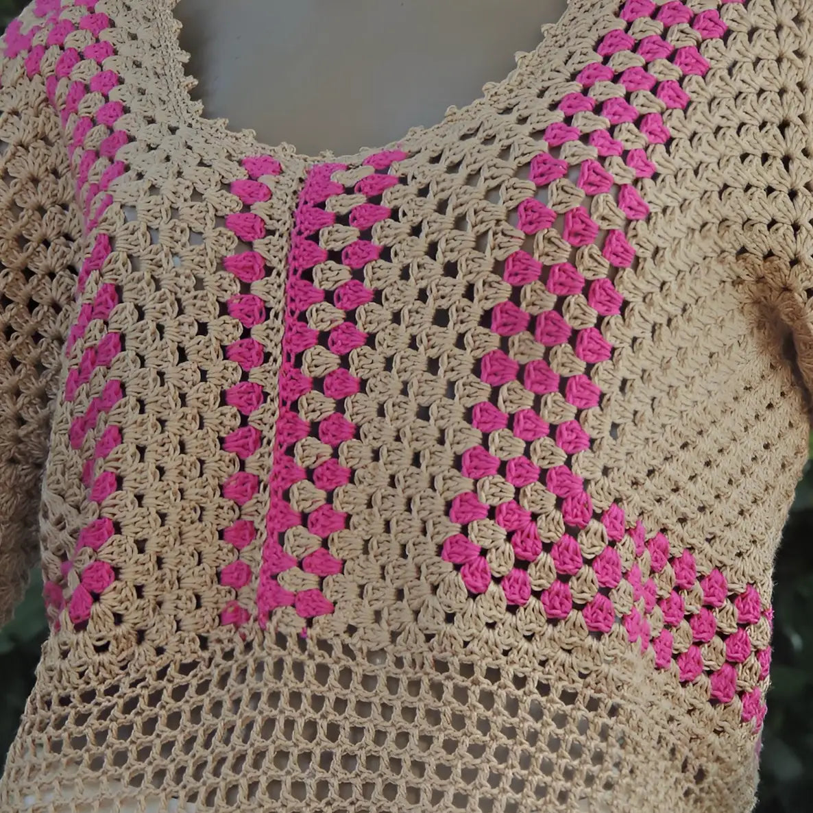 Haut au crochet Cremarosa de Cachalabibi - Gros plan sur l'encolure en V et les motifs géométriques roses