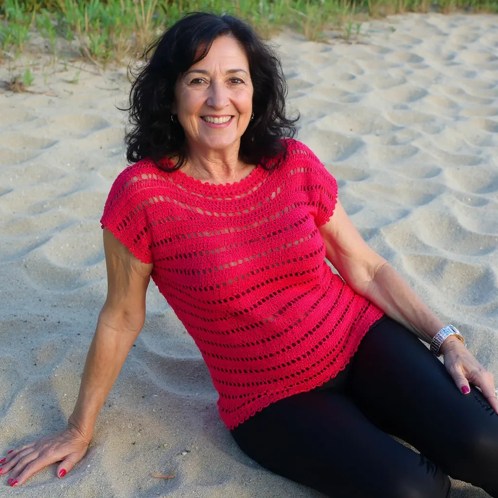 Haut au crochet Granada de Cachalabibi - vue de face d'une femme an pantalon noir allongée sur le sable