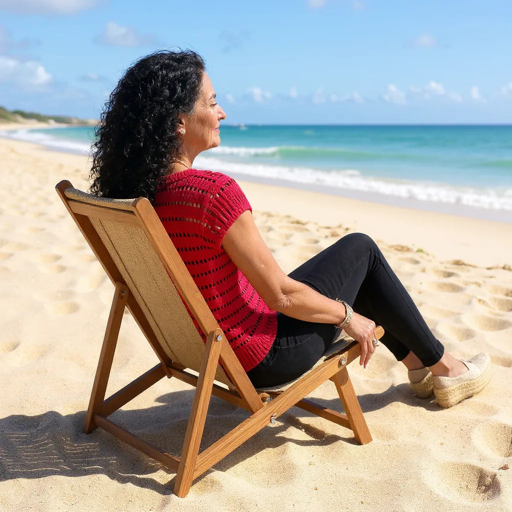 Haut au crochet Granada de Cachalabibi - vue de dos d'une femme assise sur un transat à la plage