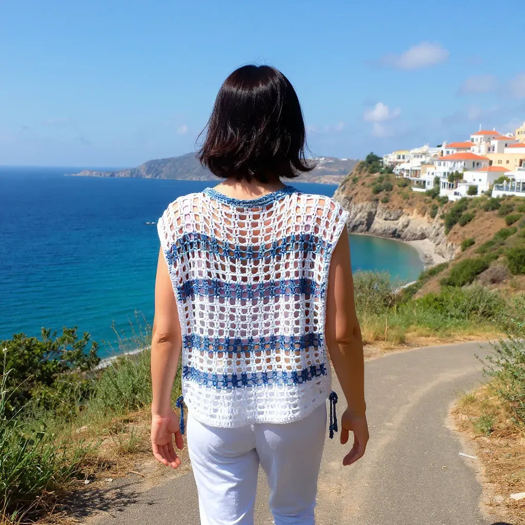 Haut au crochet Hellenica de Cachalabibi -  vue de dos d'une femme marchant sur une route avec un village crétois en fond