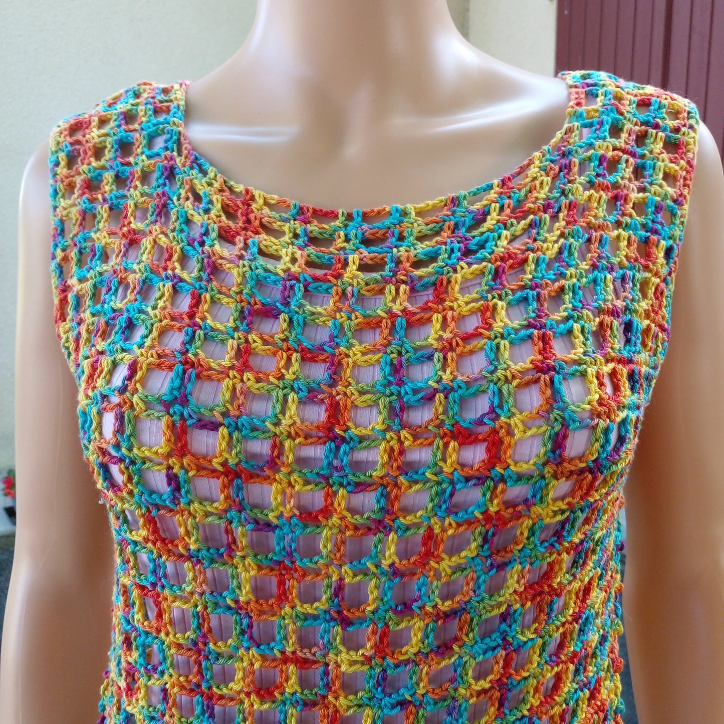 Haut au crochet Illusion de Cachalabibi - gros plan sur le point de crochet ajouré multicolore sur un mannequin