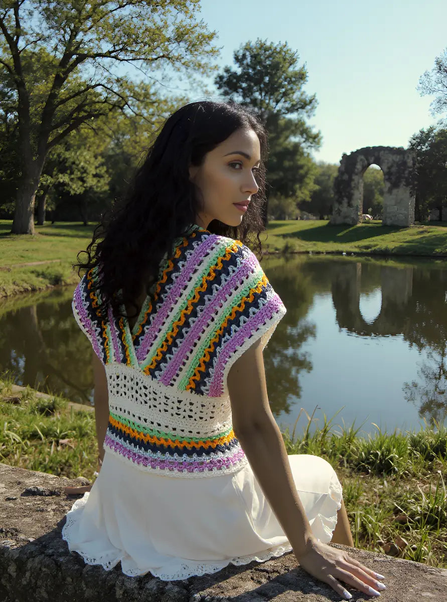 Haut au crochet Mayabella de Cachalabibi - vue de dos d'une femme assise sur une pierre devant un étang