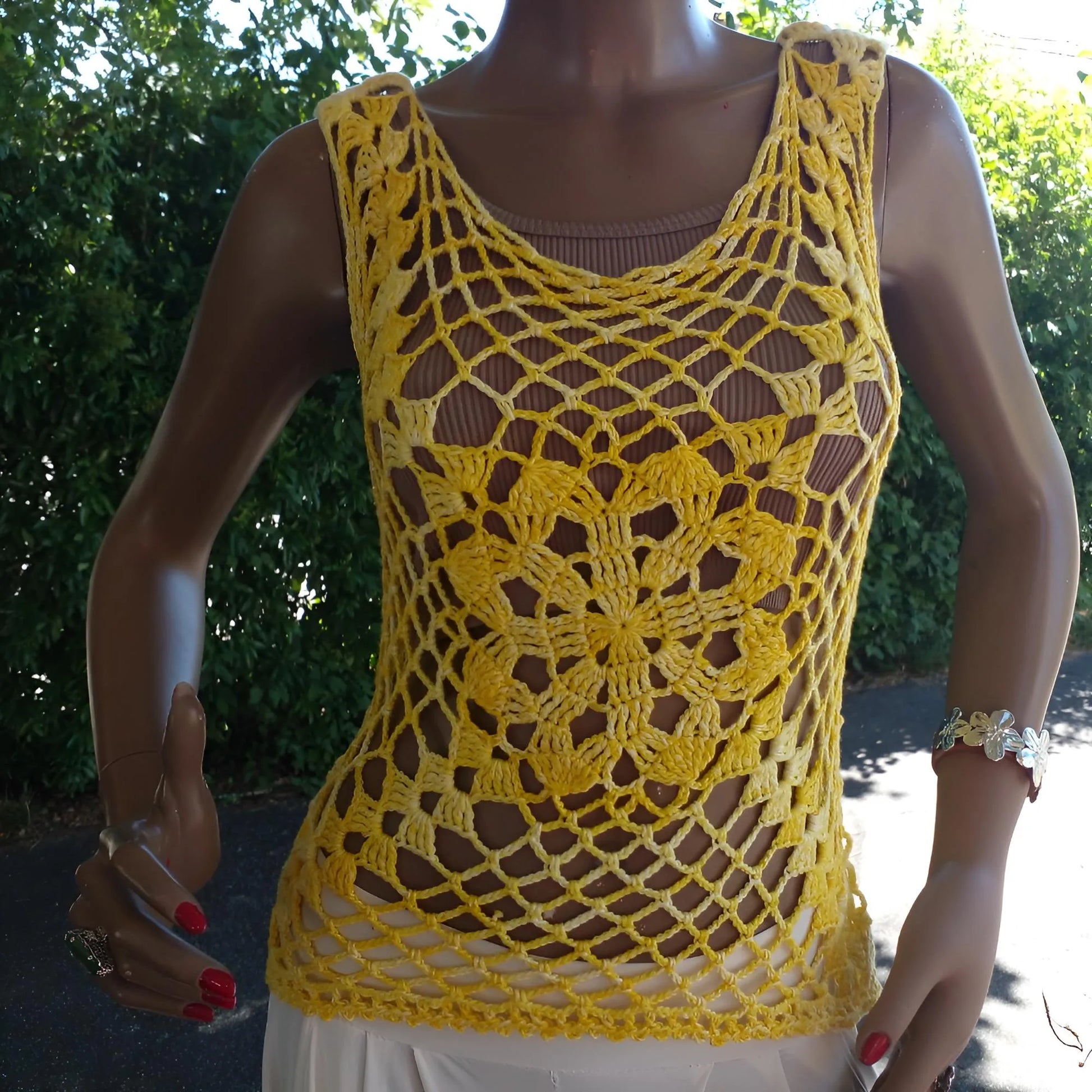 Haut au crochet Narcisola de Cachalabibi - vue de face du détail du motif floral central et du point en résille sur un mannequin