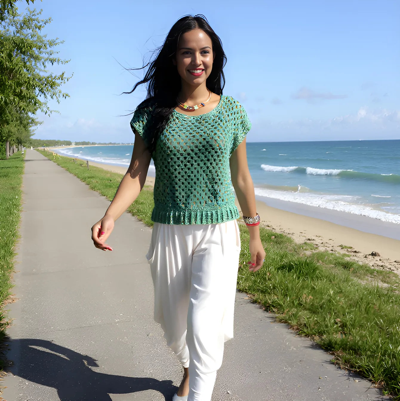 Haut au crochet Papayo de Cachalabibi -  vue de face d'une femme marchant sur un chemin bordant la plage