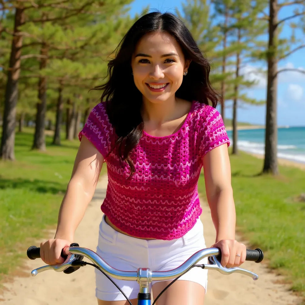 Haut au crochet Pitaya de Cachalabibi - vue de face d'une jeune femme qui fait du vélo sur un chemin près de la plage
