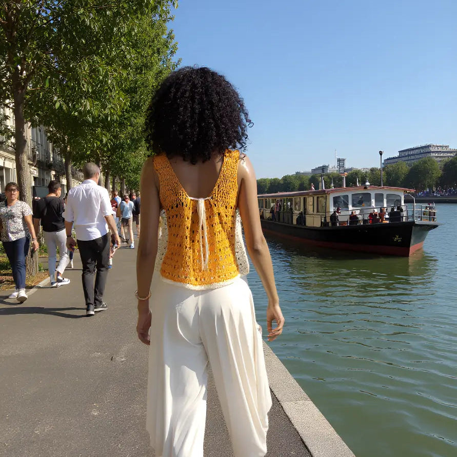 Haut au crochet Squara de Cachalabibi -vue de dos d'une jeune femme au bord d'un canal avec bateau-mouche