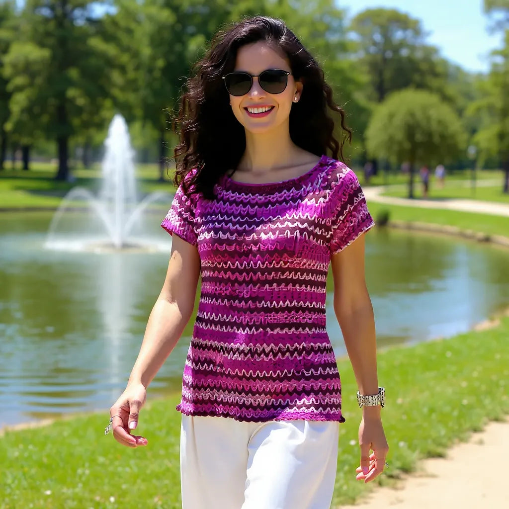 Haut au crochet Uncinetto de Cachalabibi - portée par une femme souriante dans un parc avec fontaine en arrière-plan