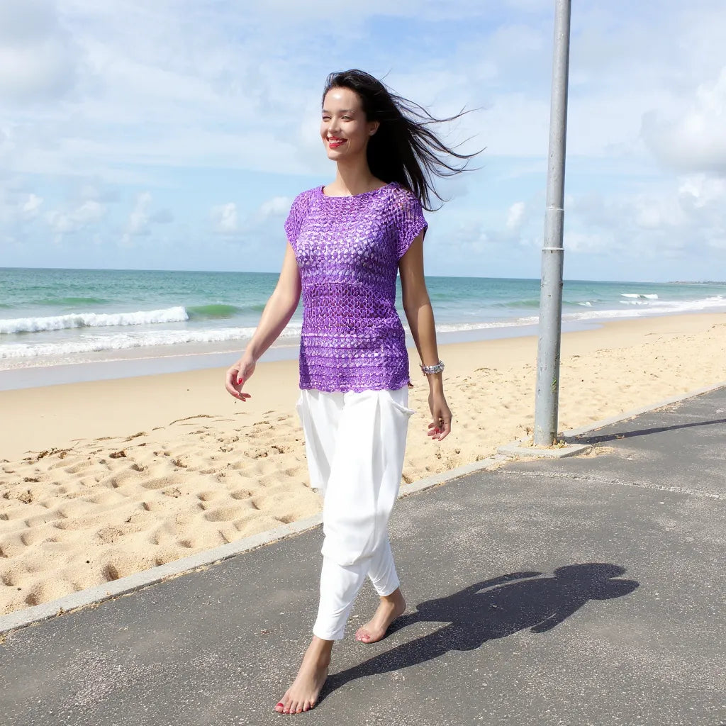 Haut au crochet Violeta de Cachalabibi - vue de face d'une femme sur un chemin longeant la plage