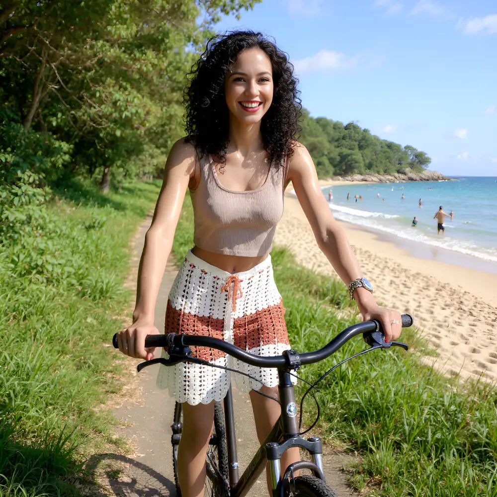 Jupe au crochet Cappuccina écru et caramel sur une femme qui fait du vélo près d'une plage