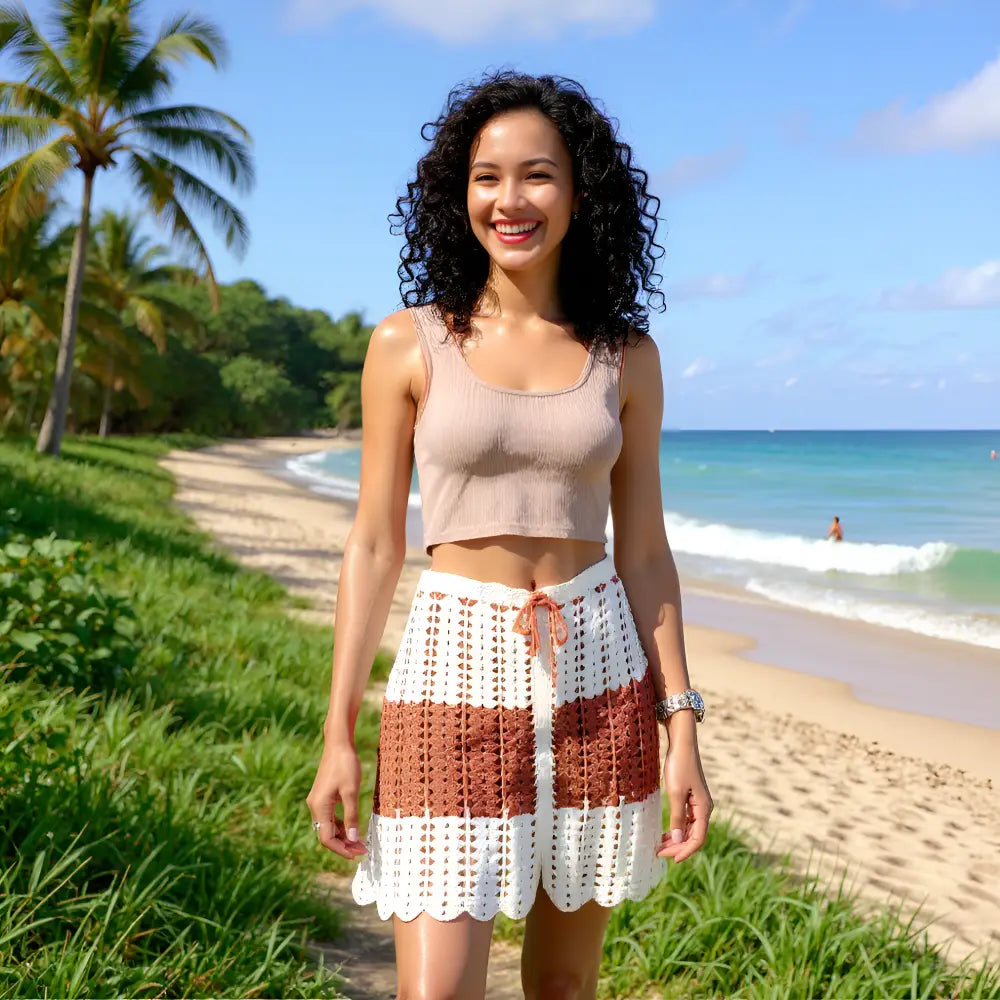 Jupe au crochet Cappuccina écru et caramel bandes horizontales portée sur une plage tropicale avec palmiers