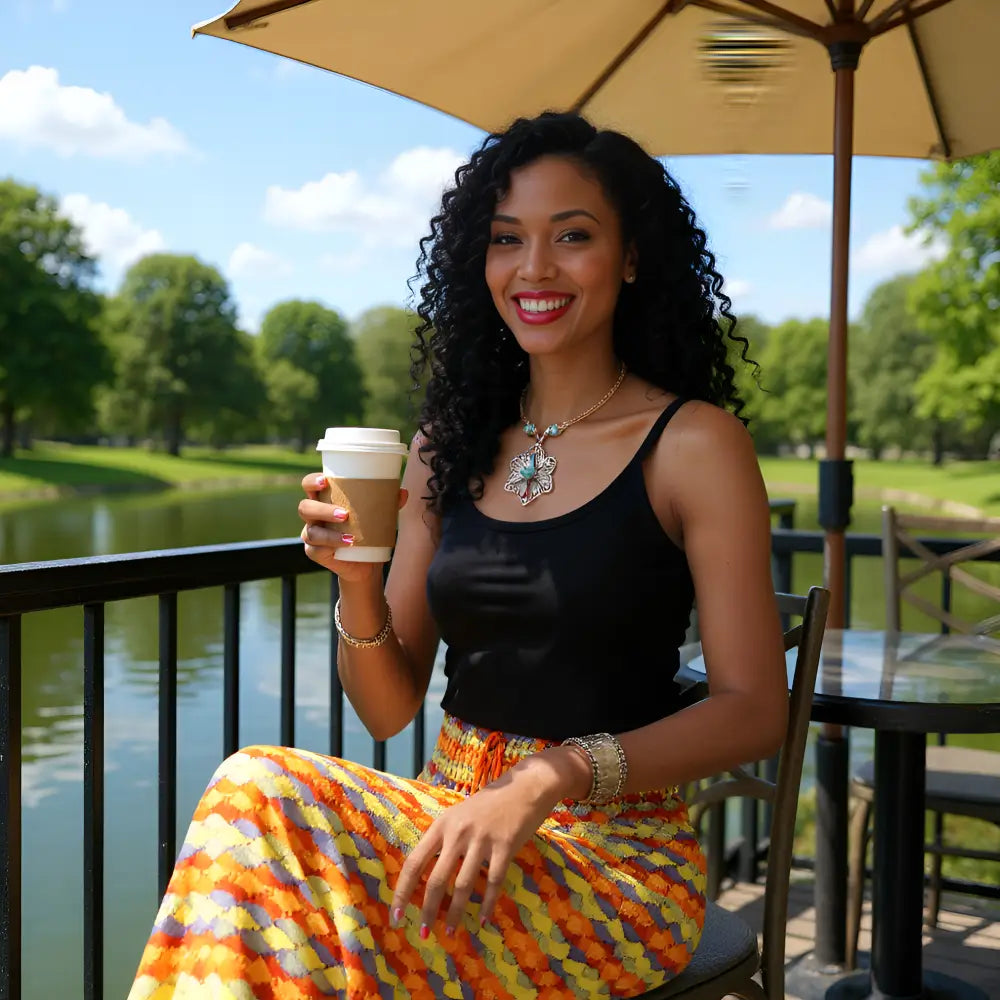 Vue de côté de la jupe Gitana multicolore d'une femme assise à une terrasse avec un bol de café à la main