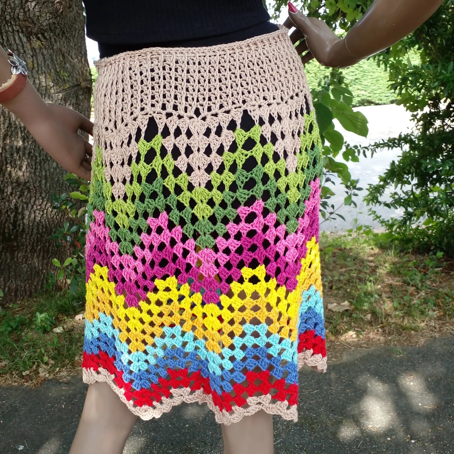 Gros plan sur les bandes horizontales multicolores en point granny square de la jupe Ondenova