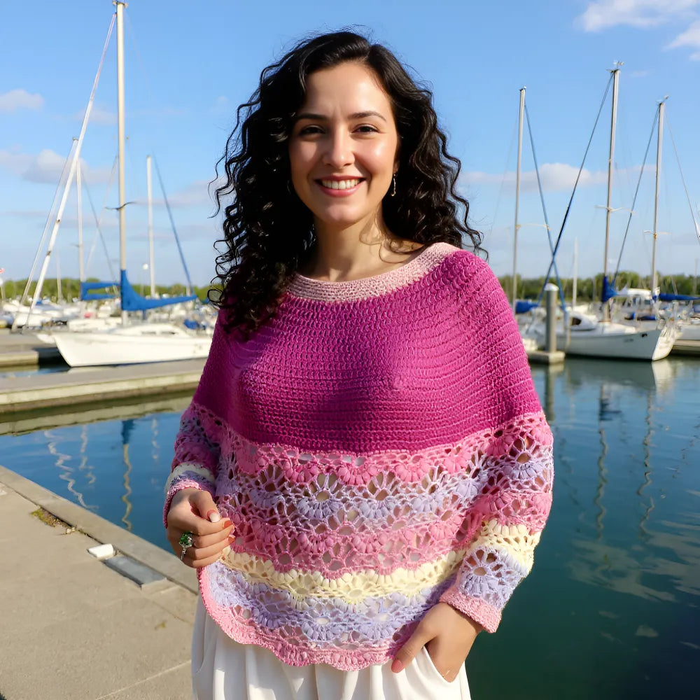 Pélerine au crochet Violina de Cachalabibi - vue de face des mailles ajourées portée devant un port de plaisance