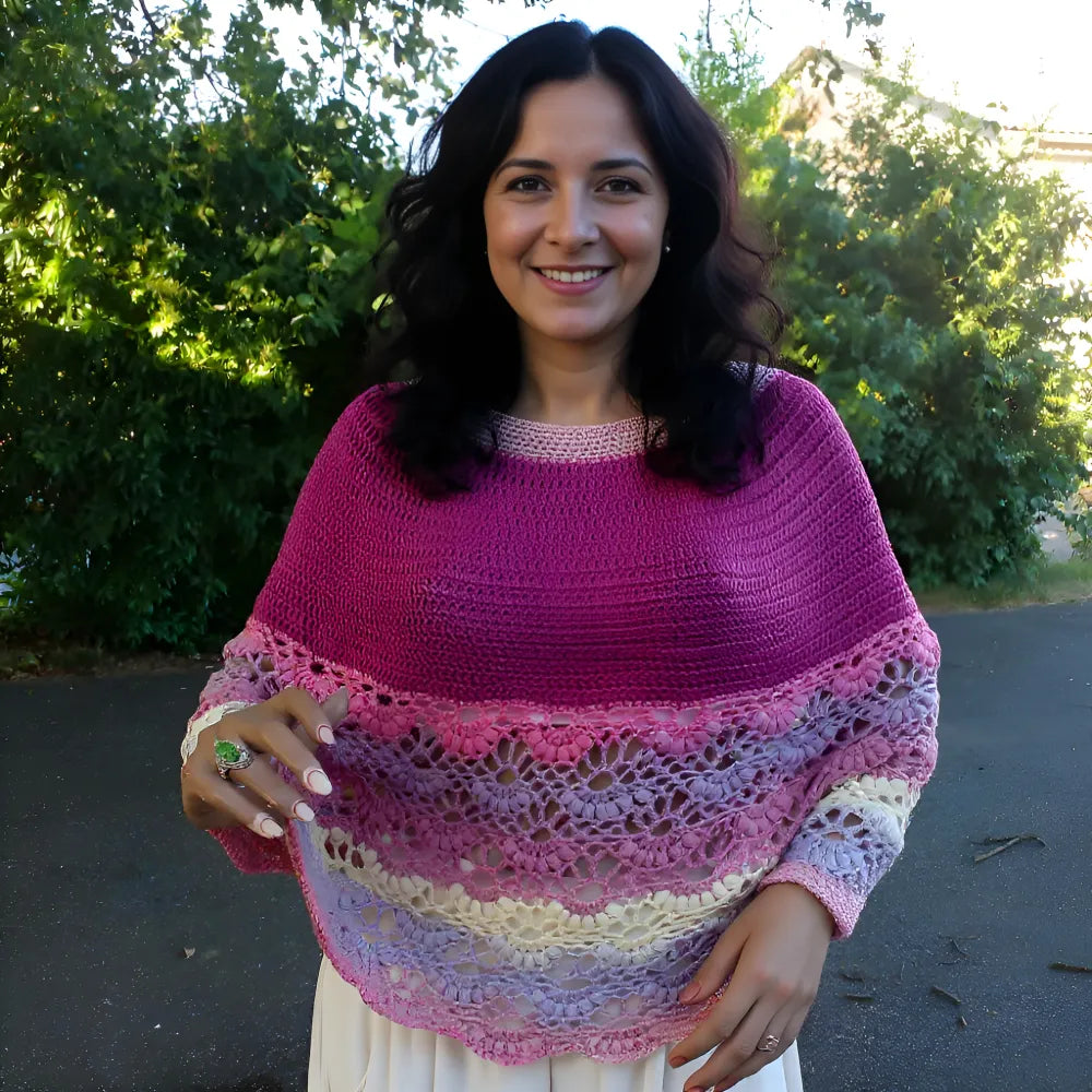 Pélerine au crochet Violina de Cachalabibi - portée en extérieur avec pantalon blanc par une jeune femme