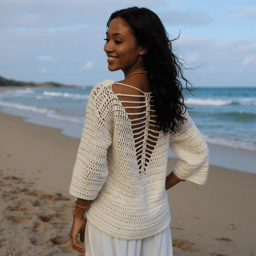 Pull au crochet Butterfly de Cachalabibi - vue de dos d'une femme aux longs cheveux noirs sur une plage