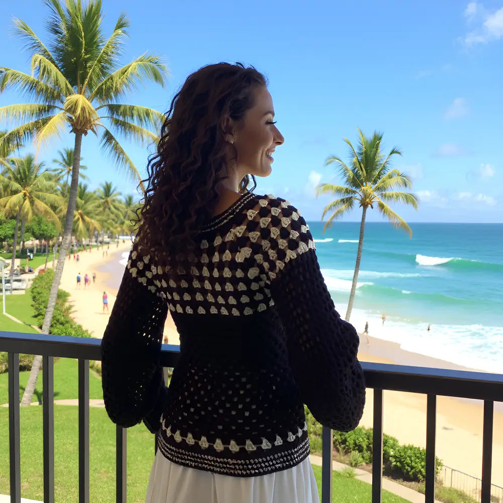 Pull au crochet Damiana de Cachalabibi - vue de dos au balcon avec vue sur la plage paradisiaque