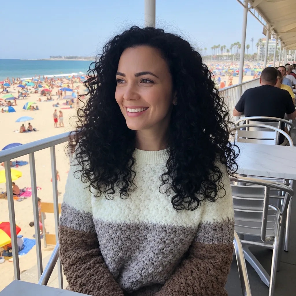Pull au crochet Passero de Cachalabibi - vue de face d'une jeune femme en terrasse près de la plage