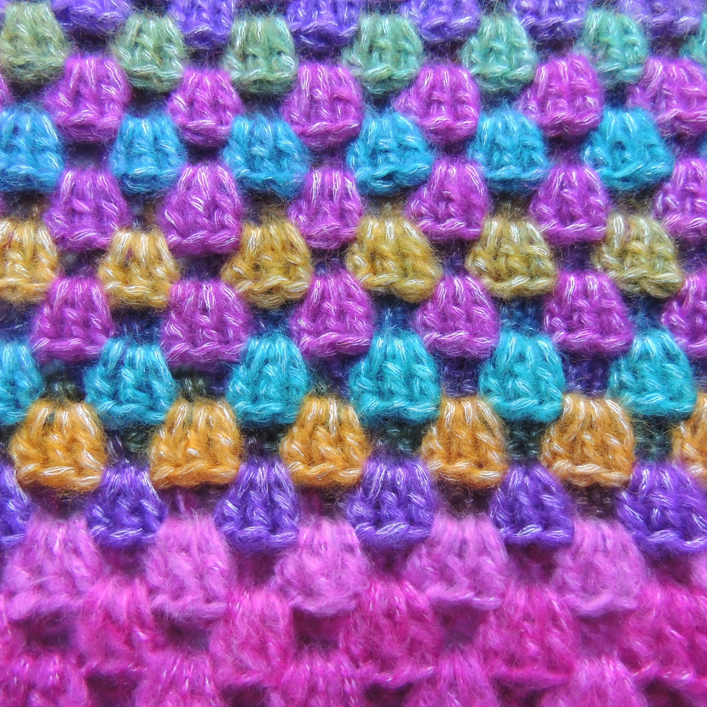 Pull au crochet Rosabella de Cachalabibi - gros plan macro sur le point granny multicolore violet rose fuchsia turquoise jaune moutarde vert menthe avec texture mohair