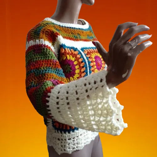 Pull au crochet Ruggino de Cachalabibi -vue de profil sur un mannequin sur fond orange dans l'atelier