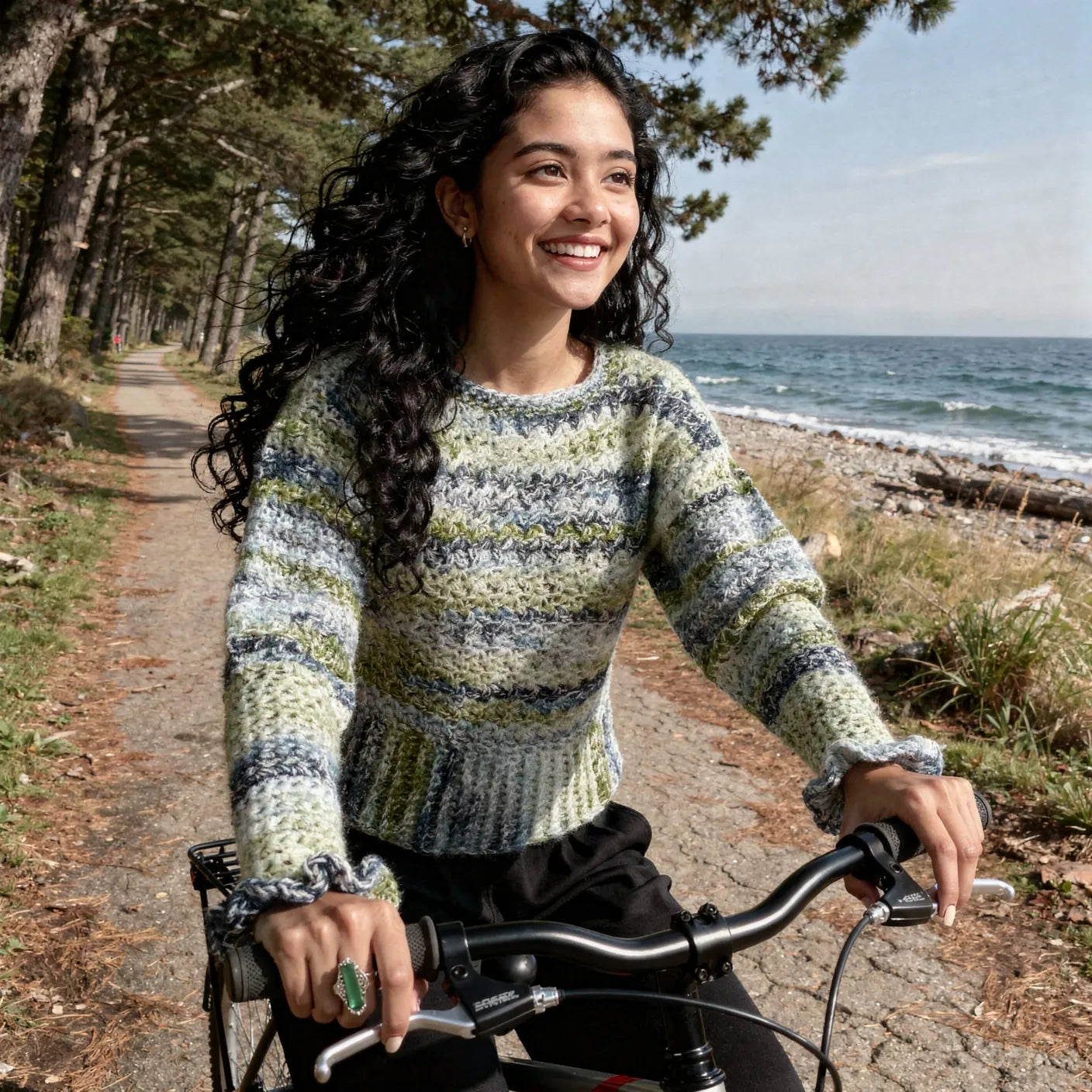 Pull au crochet Sweaty de Cachalabibi -chiné gris vert écru bleu - vue de face à vélo sur une piste cyclable en bord de mer 