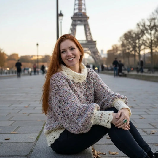 Pull au crochet Unico de Cachalabibi - vue de face assise sur un trottoir parisien avec la Tour Eiffel au loin