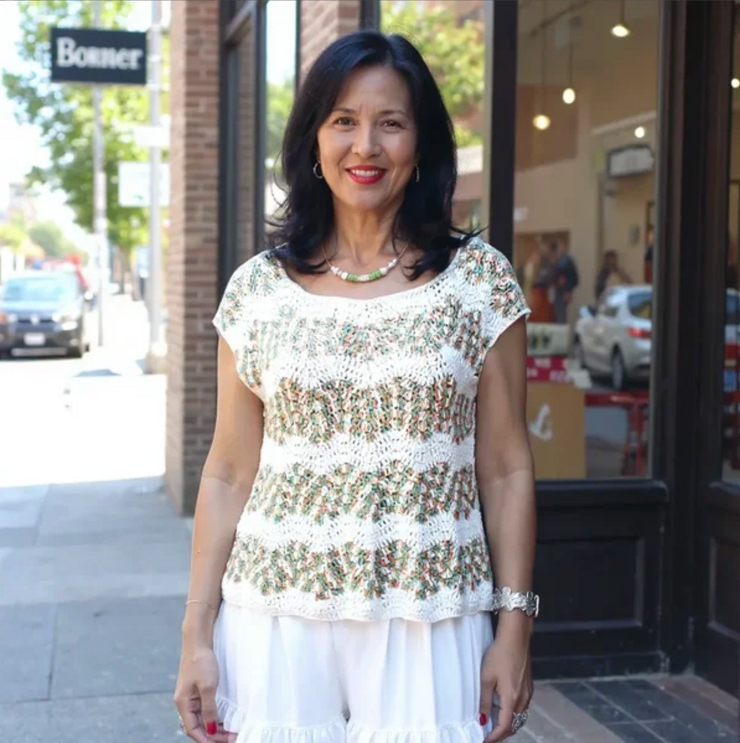 Pull au crochet Azeitona de Cachalabibi - Vue de face en rue commerçante, élégance estivale fabriquée en France