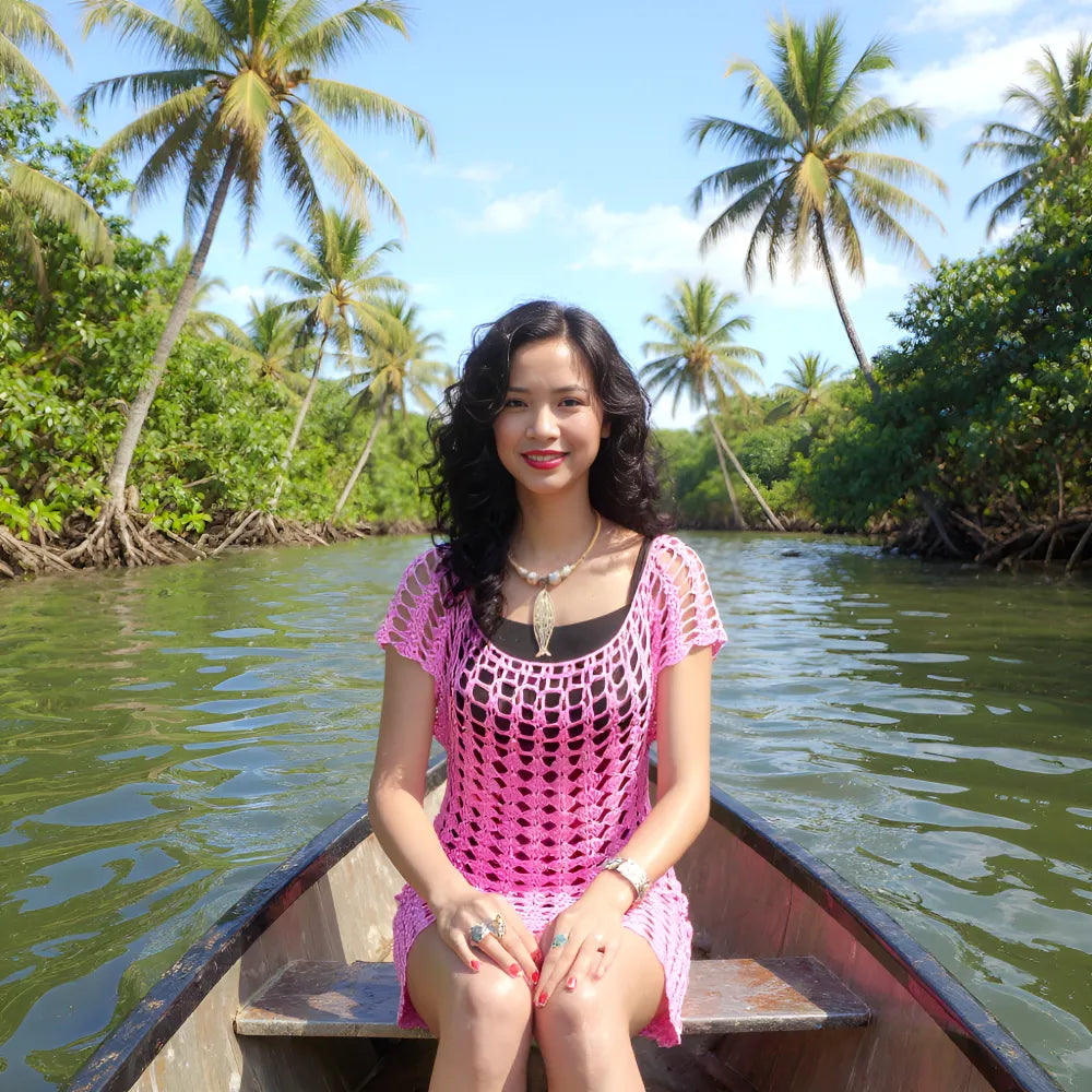Robe de bain au crochet Moorea de Cachalabibi  - vue de face d'une jeune femme assise sur une barque sur un fleuve
