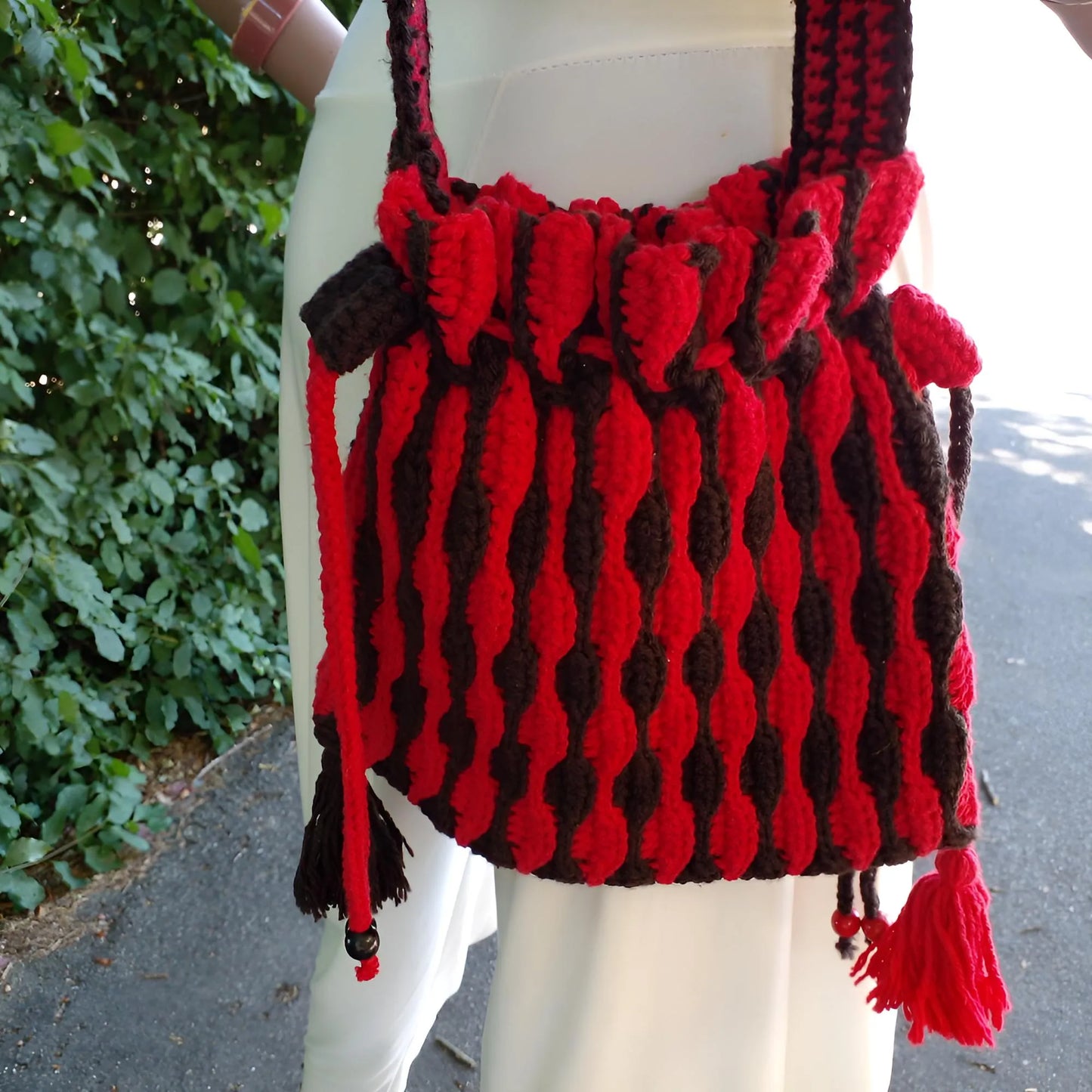 Sac à main Rossonero - gros plan sur le sac montrant la fermeture à cordon et les pompons décoratifs