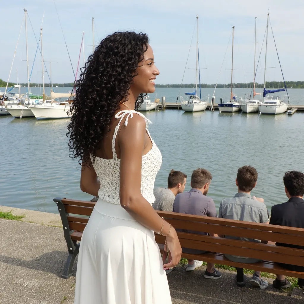 Top au crochet Kiliman de Cachalabibi - vue de profil à la marina au bord du lac d'un jeune femme souriante