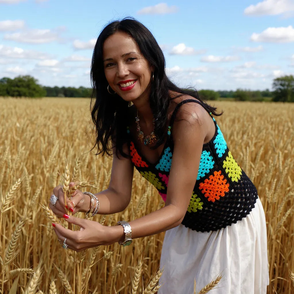 Top au crochet Quadrato de Cachalabibi - vue de face d'une jeune femme brune qui cueille des épis de blé dans un champ