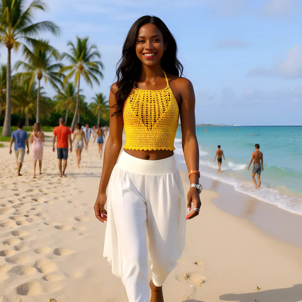 Top dos nu au crochet Giallo de Cachalabibi - vue de face d'une jeune femme souriante qui marche sur le able d'une plage tropicale