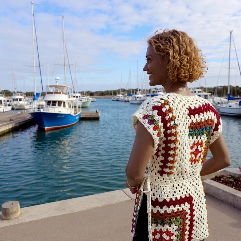 Tunique au crochet Dédalina de Cachalabibi - vue de dos d'une jeune femme dans une marina qui regarde les bateaux