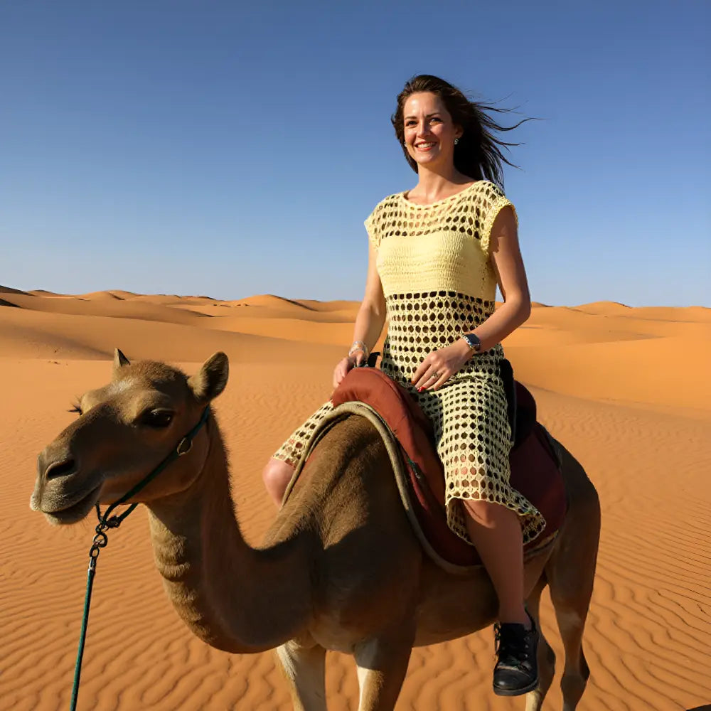 Tunique au crochet Sahara de Cachalabibi - femme de30 ans montée sur un chameau dans le désert