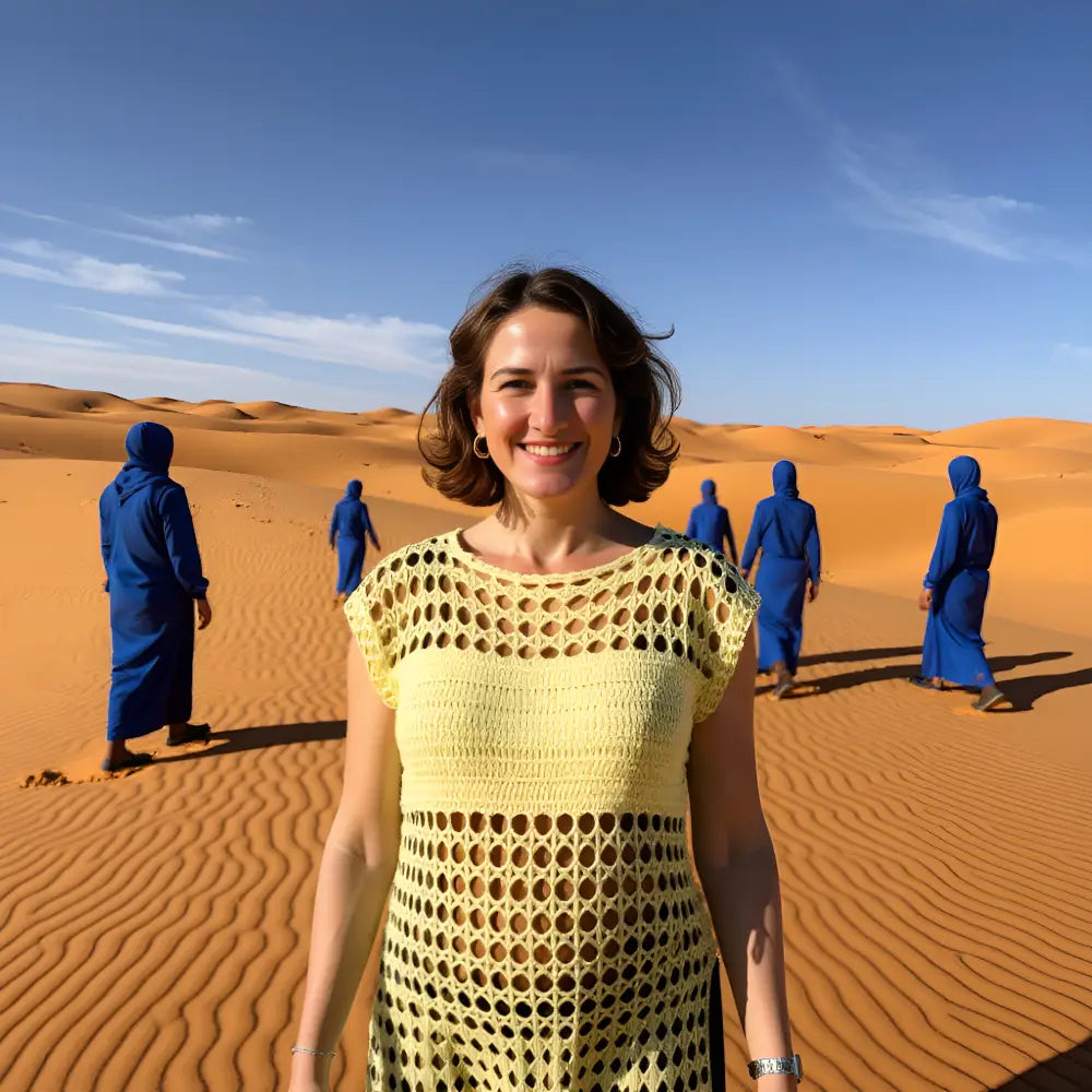 Tunique au crochet Sahara de Cachalabibi - portée par une femme dans le désert avec des touaregs en arrière-plan